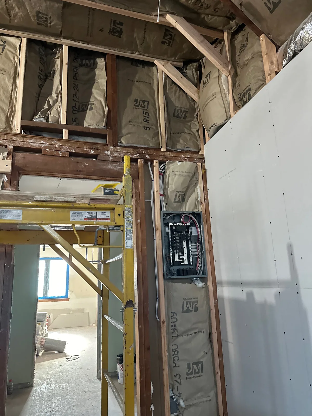 Attic renovation in progress with new insulation, drywall going up and a new electrical panel