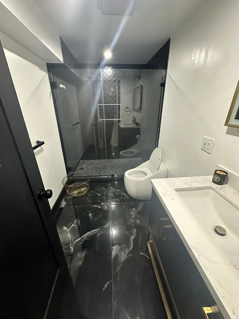 Hackensack, NJ bathroom remodel: black marble-look floor tile through the doorway