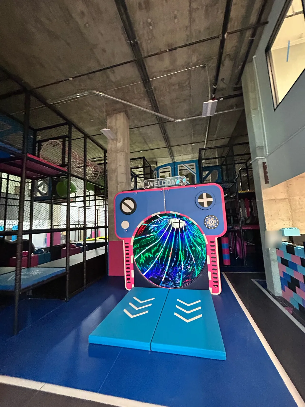 Finished kids' indoor play area with a netted climbing structure and soft play pieces
