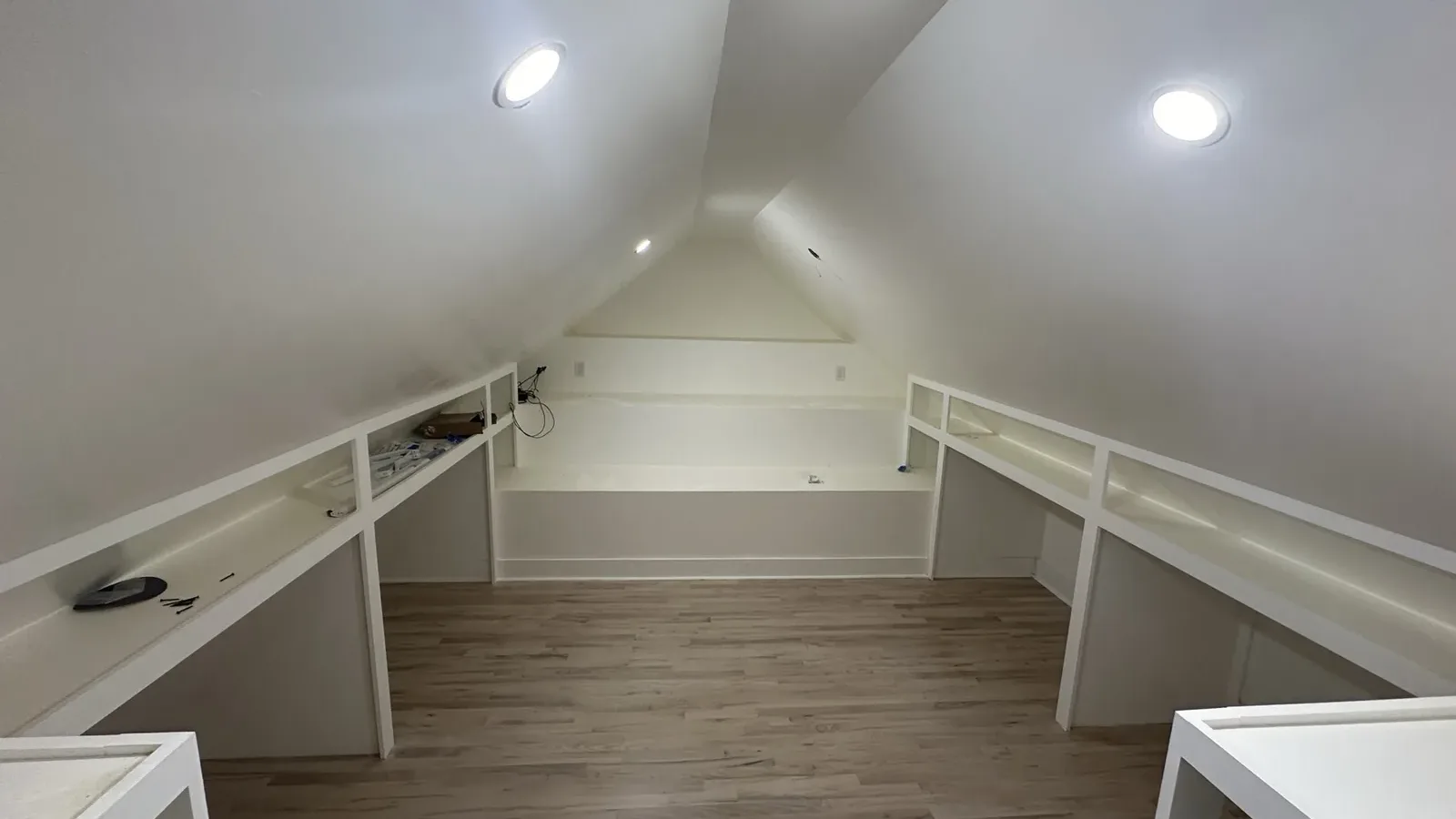 Finished attic level with built-in shelving and knee-wall storage under a sloped ceiling