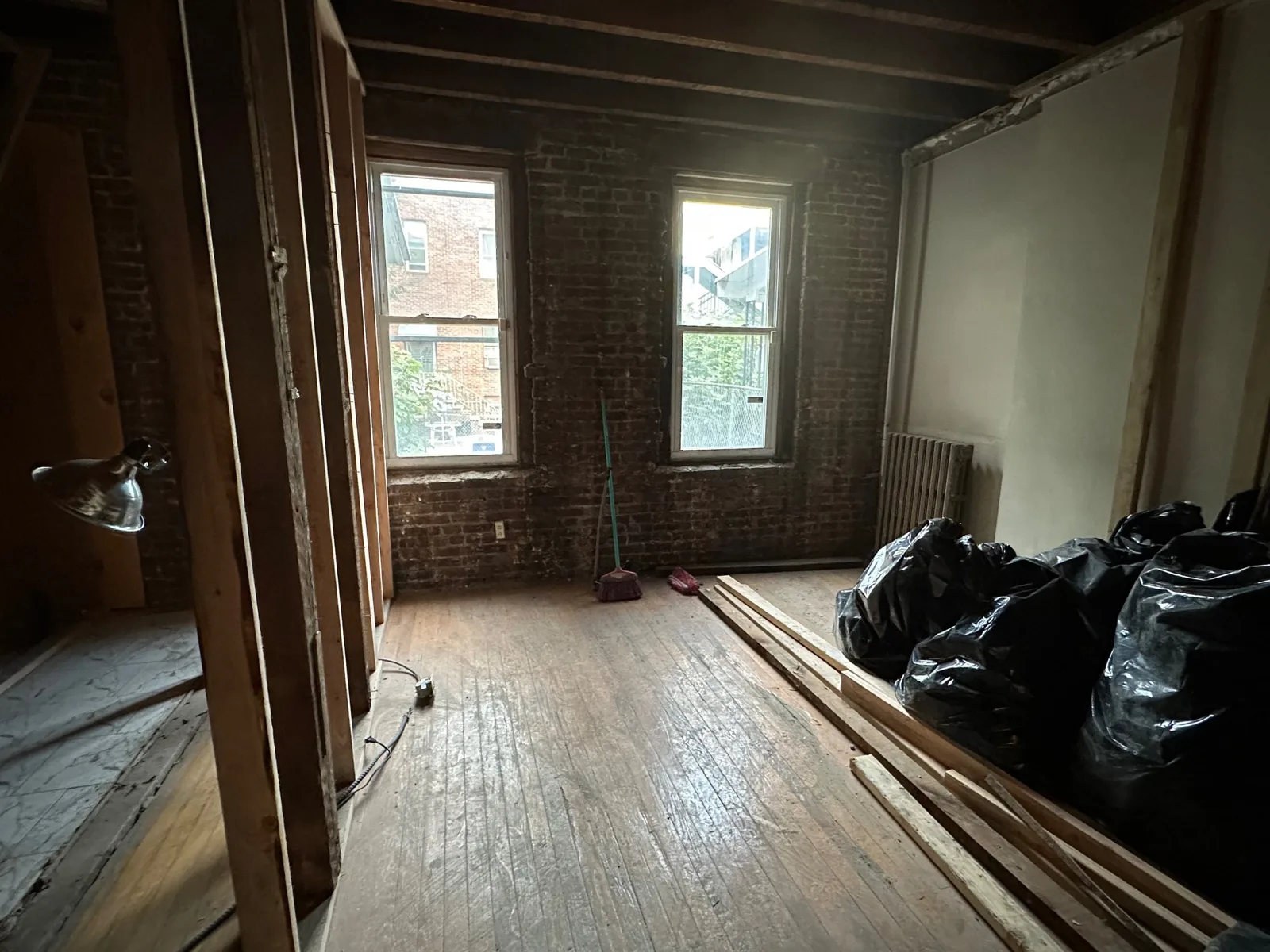 Union City gut renovation after demolition, down to brick walls, old wood floor and exposed ceiling joists