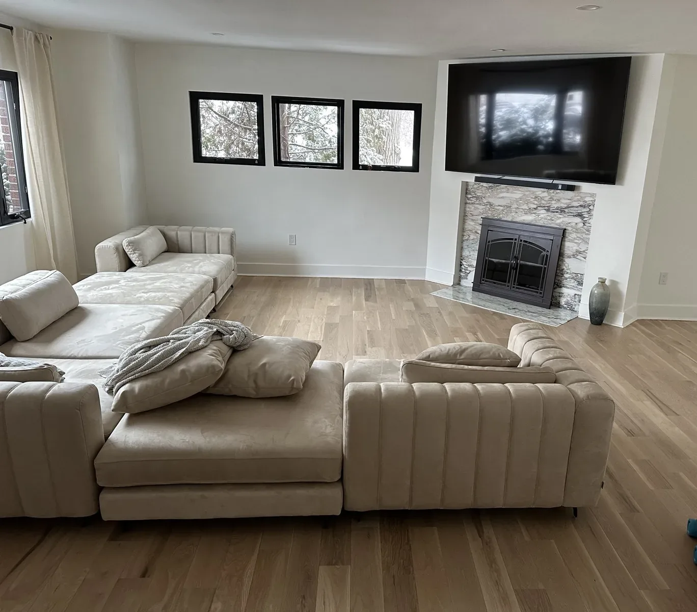 Living room with new hardwood floors and a stone-surround fireplace in Hackensack, NJ