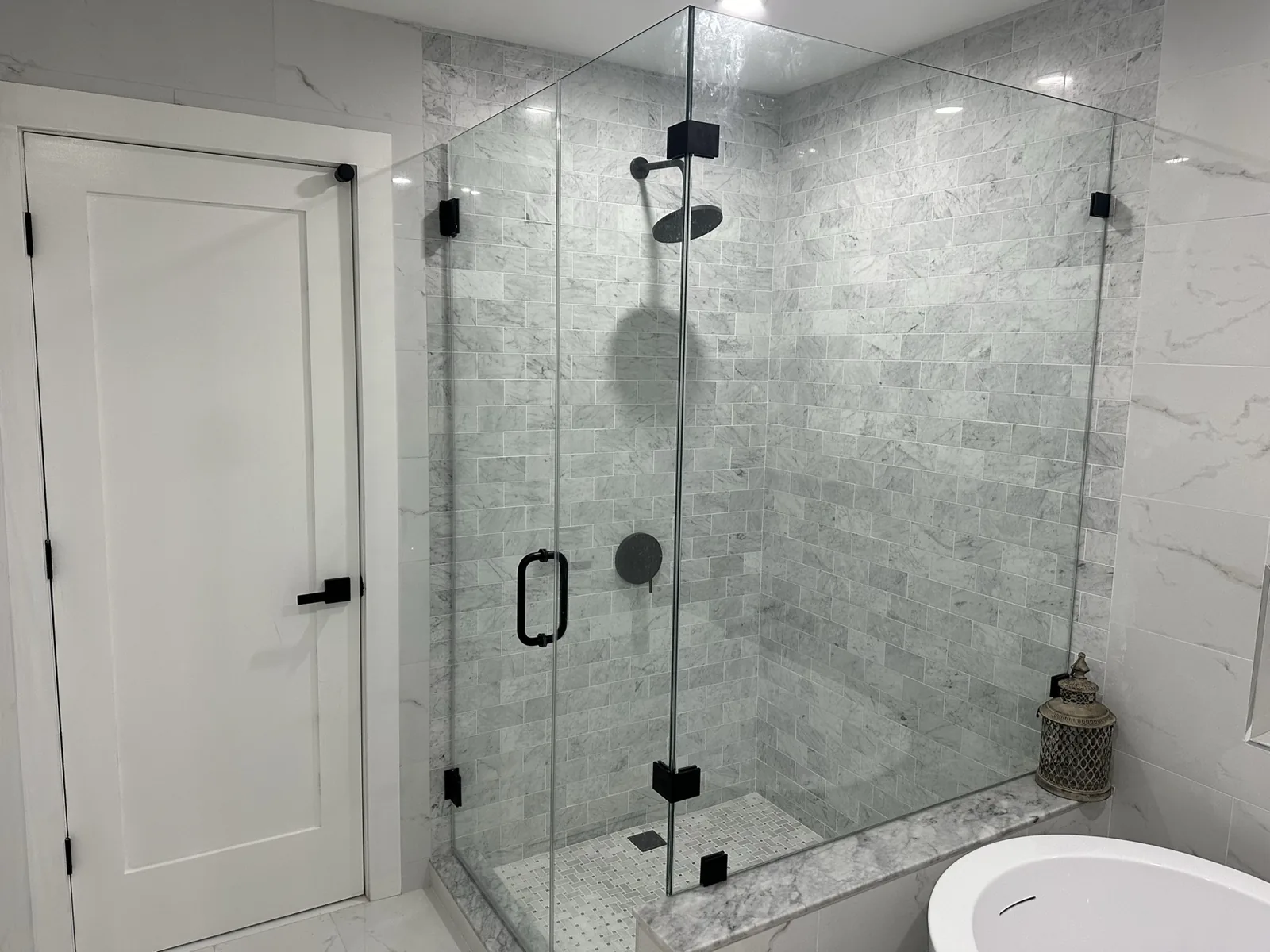 Frameless glass shower in marble-look subway tile in Hackensack, NJ