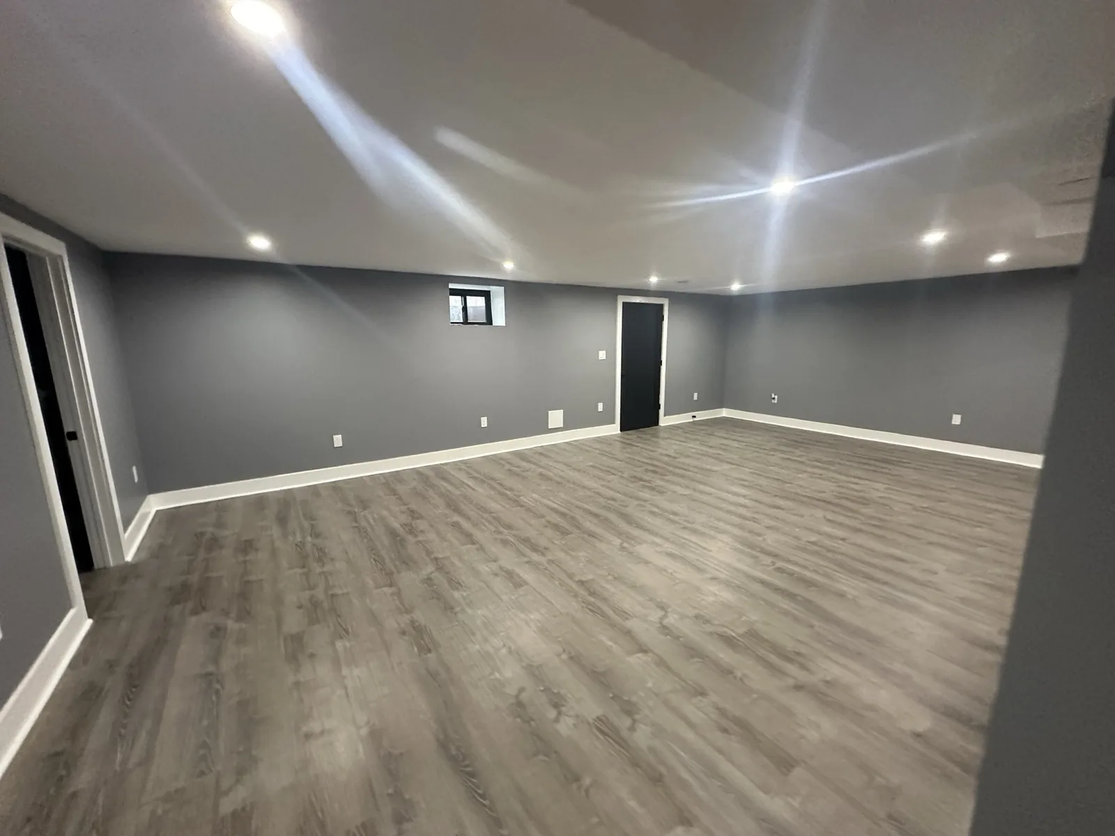 Finished basement with painted walls, lighting and new flooring in Hackensack, NJ