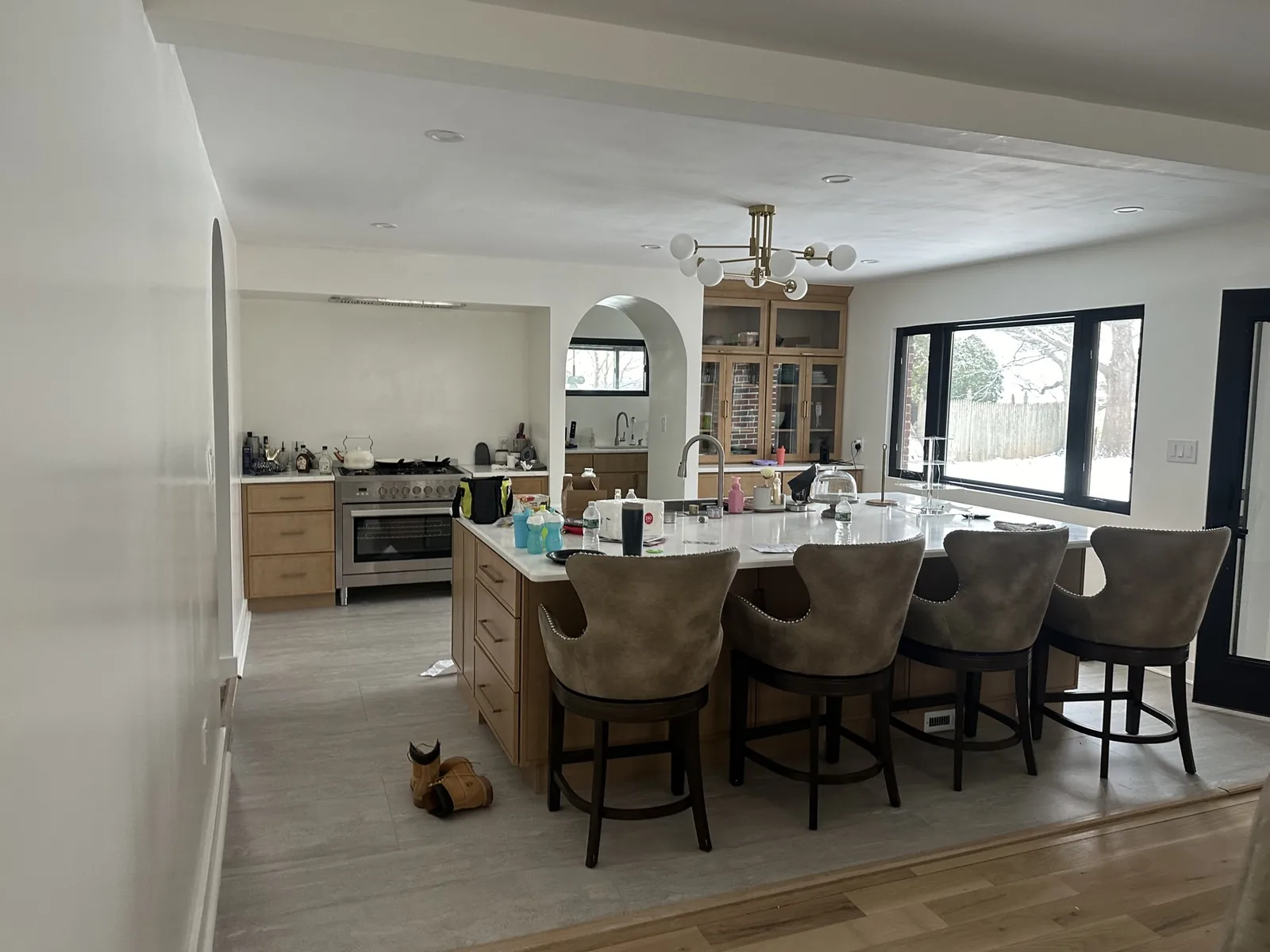 Renovated kitchen in Hackensack, NJ with natural wood cabinetry, a quartz island and seating for four