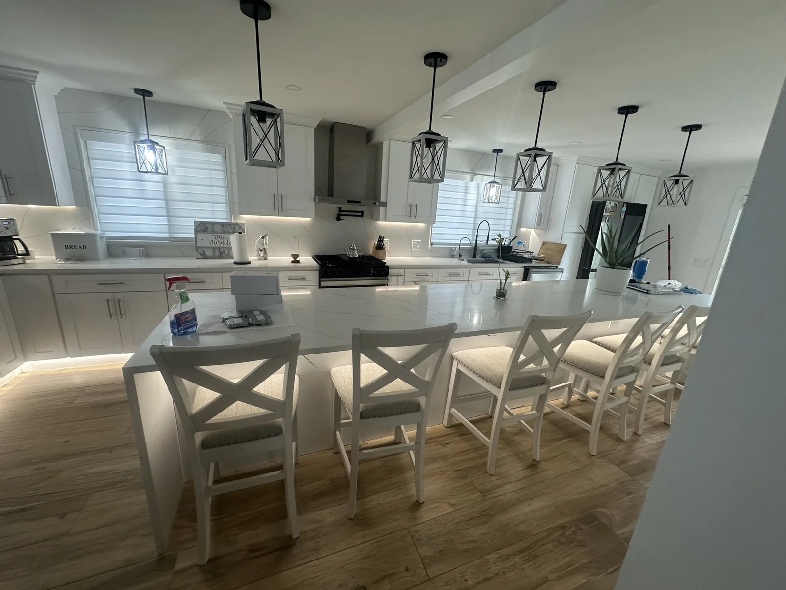 Open-plan kitchen and dining area with quartz counters and under-cabinet lighting