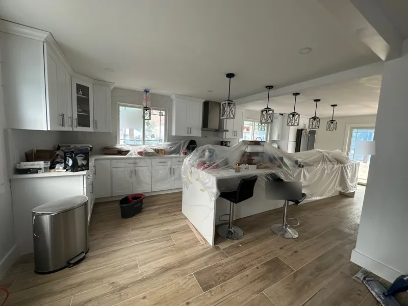 Kitchen remodel in progress in Lake Hiawatha, NJ: white shaker cabinets and island set, counters wrapped in plastic