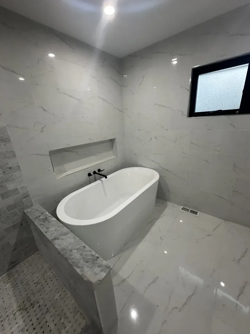Hackensack, NJ bathroom remodel: freestanding tub with a wall-mounted matte black filler and basketweave floor